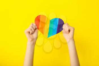 Female hands with rainbow heart on color background. LGBT concept�