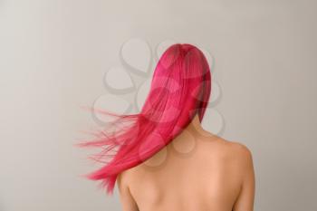 Beautiful young woman with unusual hair color on light background 