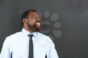 African-American teacher near blackboard in classroom�