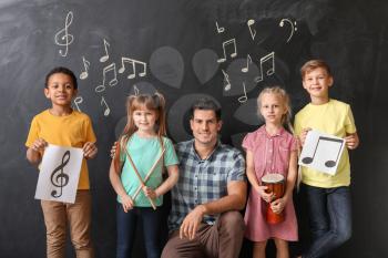 Music teacher with little children at school�