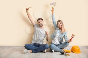 Young couple with tools resting during repair in new apartment�