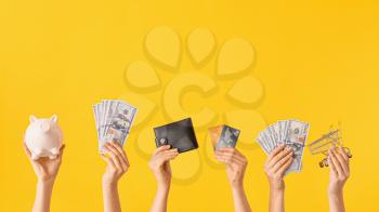 Female hands with money, credit cards, piggy bank, wallet and shopping cart on color background. Concept of online banking�