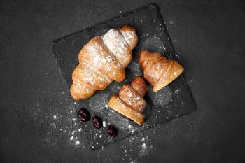 Tasty sweet croissants with jam on dark background�