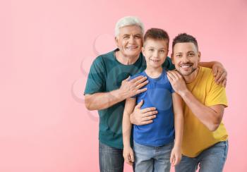 Man with his father and son on color background�