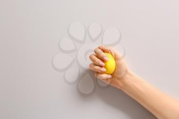 Hand squeezing stress ball on light background�