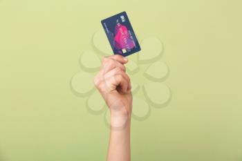 Female hand with credit card on color background�