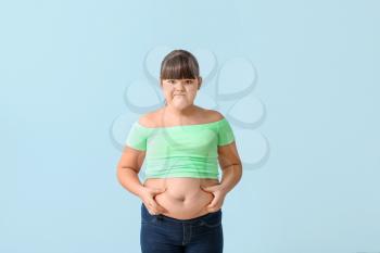 Sad overweight girl on color background�