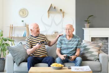 Elderly men playing video games at home�