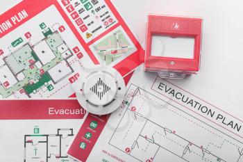 Evacuation plans, smoke detector and manual call point on white background�