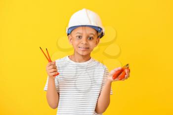 Little African-American electrician on color background�