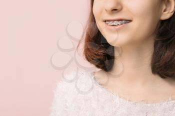 Teenage girl with dental braces on color background, closeup�