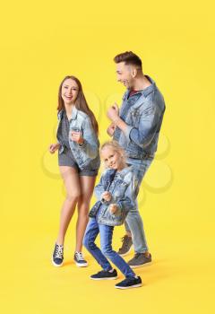 Happy family dancing against color background�