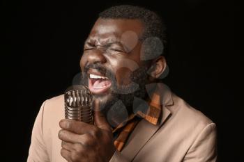 Male African-American singer on dark background�