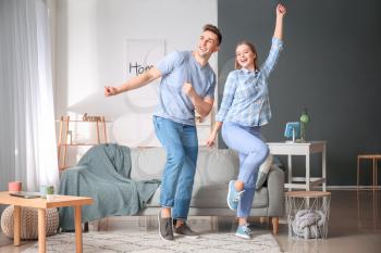 Happy young couple dancing at home�