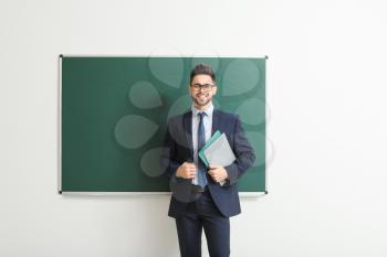 Male teacher near blackboard in classroom�