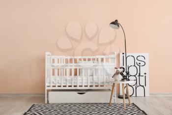 Baby bed near wall in interior of children's room�