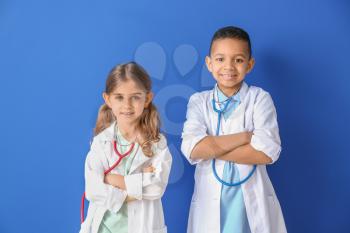 Cute little doctors on color background�