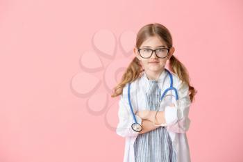 Cute little doctor on color background�