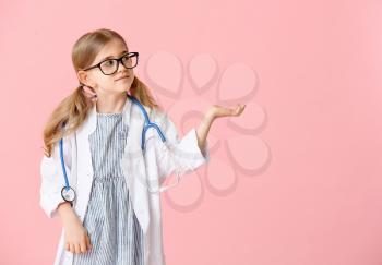 Cute little doctor on color background�