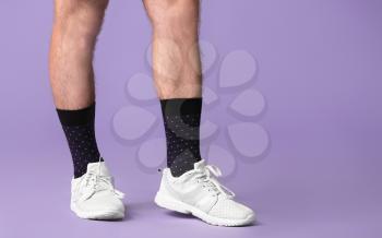 Male legs in socks and shoes on color background�