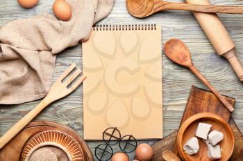 Cook book with products on wooden background�
