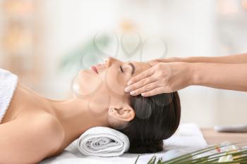 Beautiful young woman receiving facial massage in spa salon�