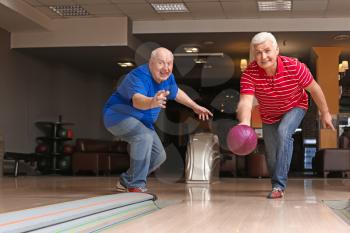 Senior people playing bowling in club�