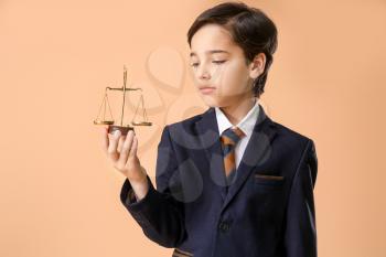 Little lawyer with scales of justice on color background�