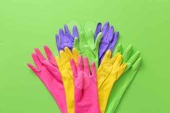 Set of rubber gloves on color background�