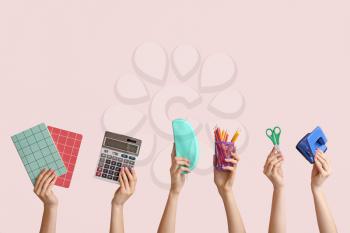 Many hands with school supplies on light background�