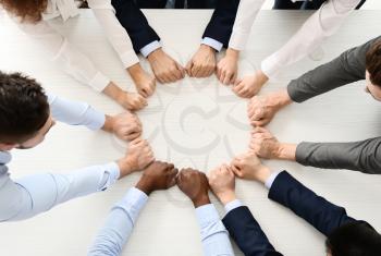 Group of business people putting hands together in office, top view. Unity concept�