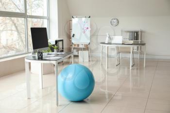 Fitness ball near workplace in office�