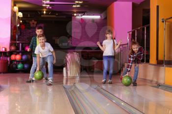 Little children playing bowling in club�