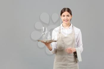 Portrait of female waiter on grey background�