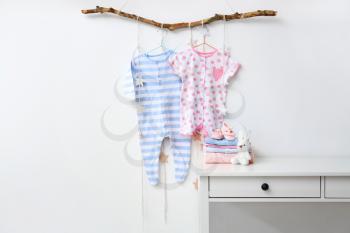 Baby clothes with booties and toy in room�