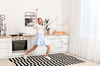 Beautiful young woman dancing at home�