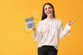 Young woman with calculator on color background�