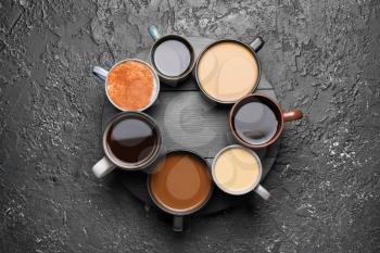 Composition with cups of different coffee on grunge background�