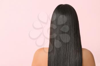 Young Asian woman with beautiful long hair on color background�