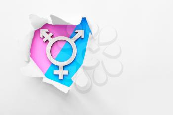 Symbol of transgender visible through torn paper on color background�