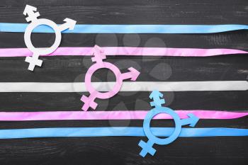 Symbols of transgender with ribbons on dark wooden background�