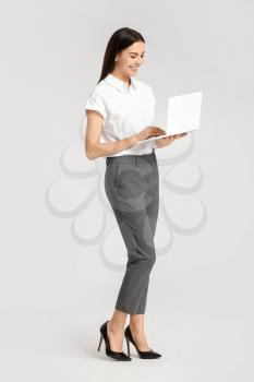 Beautiful young secretary with laptop on white background�