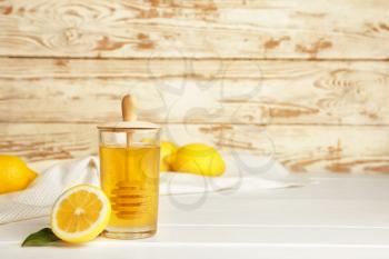 Jar of sweet honey and lemon on table�