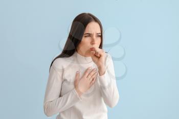Coughing young woman on light background�