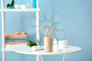 Tooth brushes in holder on table in bathroom�