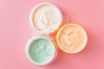 Jars of cosmetic cream on color background�