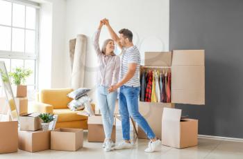 Young couple having fun while unpacking things in their new flat on moving day�