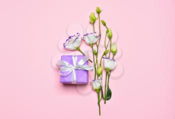 Birthday gift with flowers on color background�