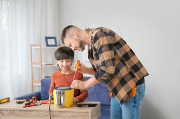 Father and little son repairing toaster at home�