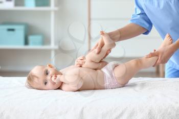 Massage therapist working with cute baby in medical center 